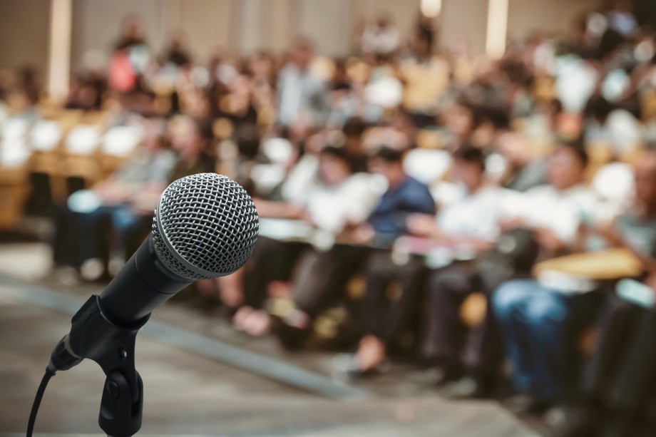 Microphone over the Abstract blurred photo of conference hall or seminar room with attendee background